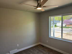 Empty room featuring a textured ceiling, ceiling fan, and carpet