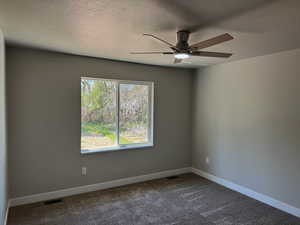 Unfurnished room featuring ceiling fan, a textured ceiling, and carpet