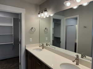 Full bathroom with a walk in closet, double vanity, and a shower stall.