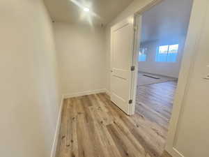 Hallway with baseboards and light wood-style flooring