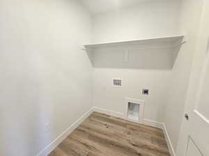 Laundry room with light wood-style flooring, hookup for an electric dryer, and washer hookup