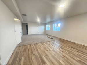Empty room with baseboards and light wood-type flooring