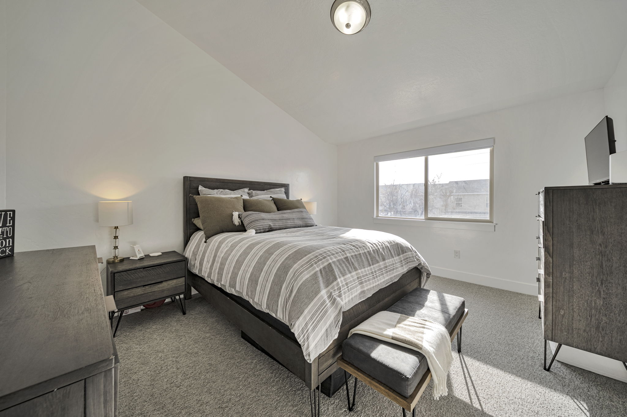 Bedroom featuring lofted ceiling and light carpet