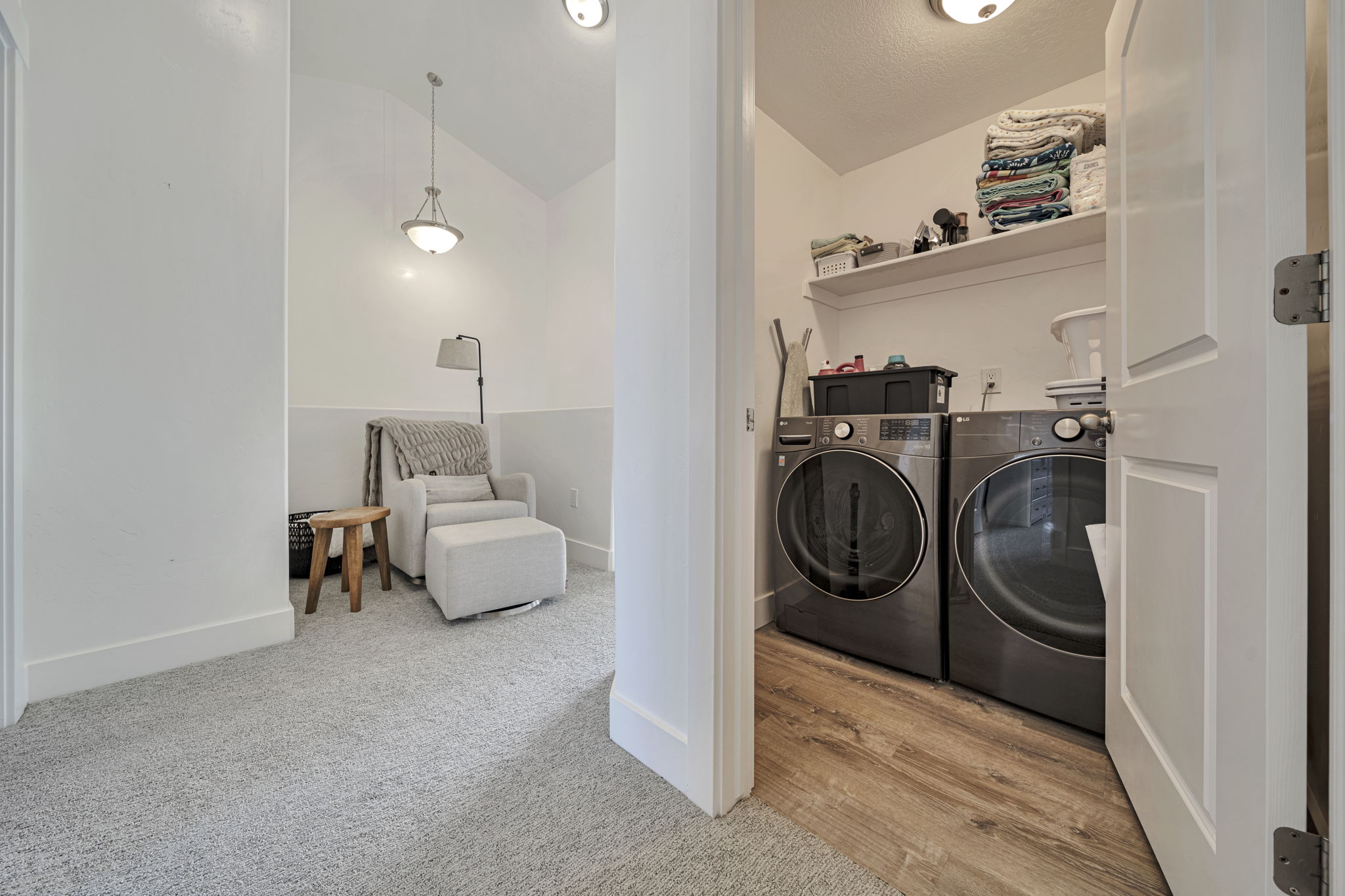 Laundry area featuring vaulted ceiling, washer and clothes dryer, and light carpet