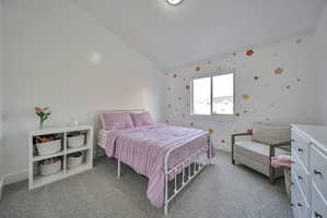 Bedroom featuring lofted ceiling and light colored carpet