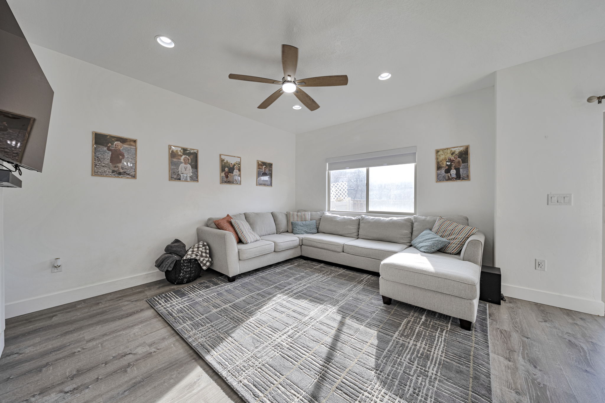 Living room featuring light wood-style flooring, recessed lighting, and a ceiling fan