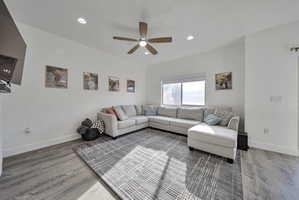 Living room featuring light wood-style flooring, recessed lighting, and a ceiling fan