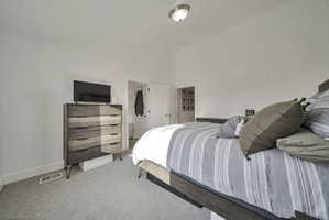 Bedroom with light colored carpet and baseboards