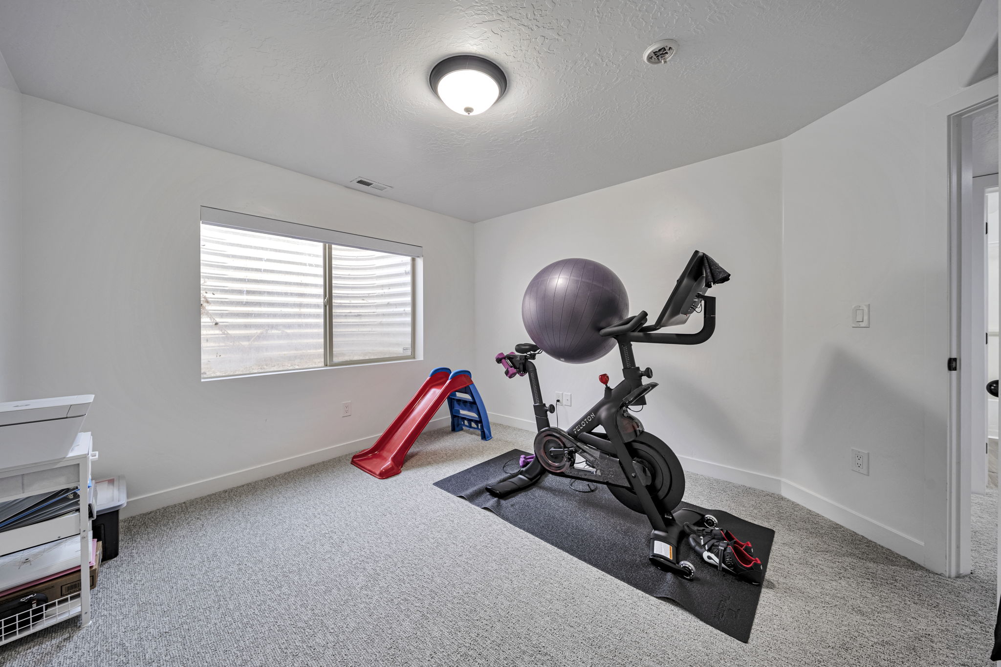 Workout area with a textured ceiling and light colored carpet