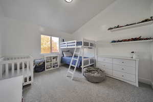 Bedroom featuring vaulted ceiling and light carpet