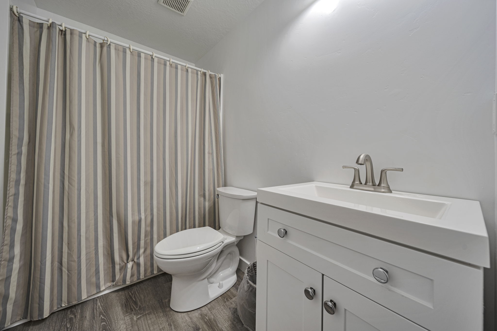 Bathroom featuring vanity, dark wood finished floors, and a textured ceiling
