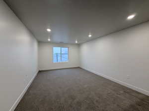 Spare room featuring dark carpet and recessed lighting
