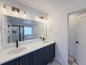 Full bath with light floors, a stall shower, double vanity, and a garden tub