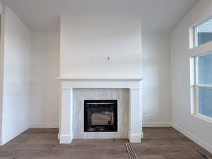 Detailed view of wood finished floors and a fireplace