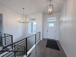 Entryway with a chandelier and dark wood finished floors