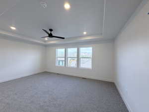 Carpeted spare room with recessed lighting, a ceiling fan, and a raised ceiling