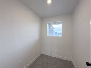 Carpeted empty room featuring baseboards
