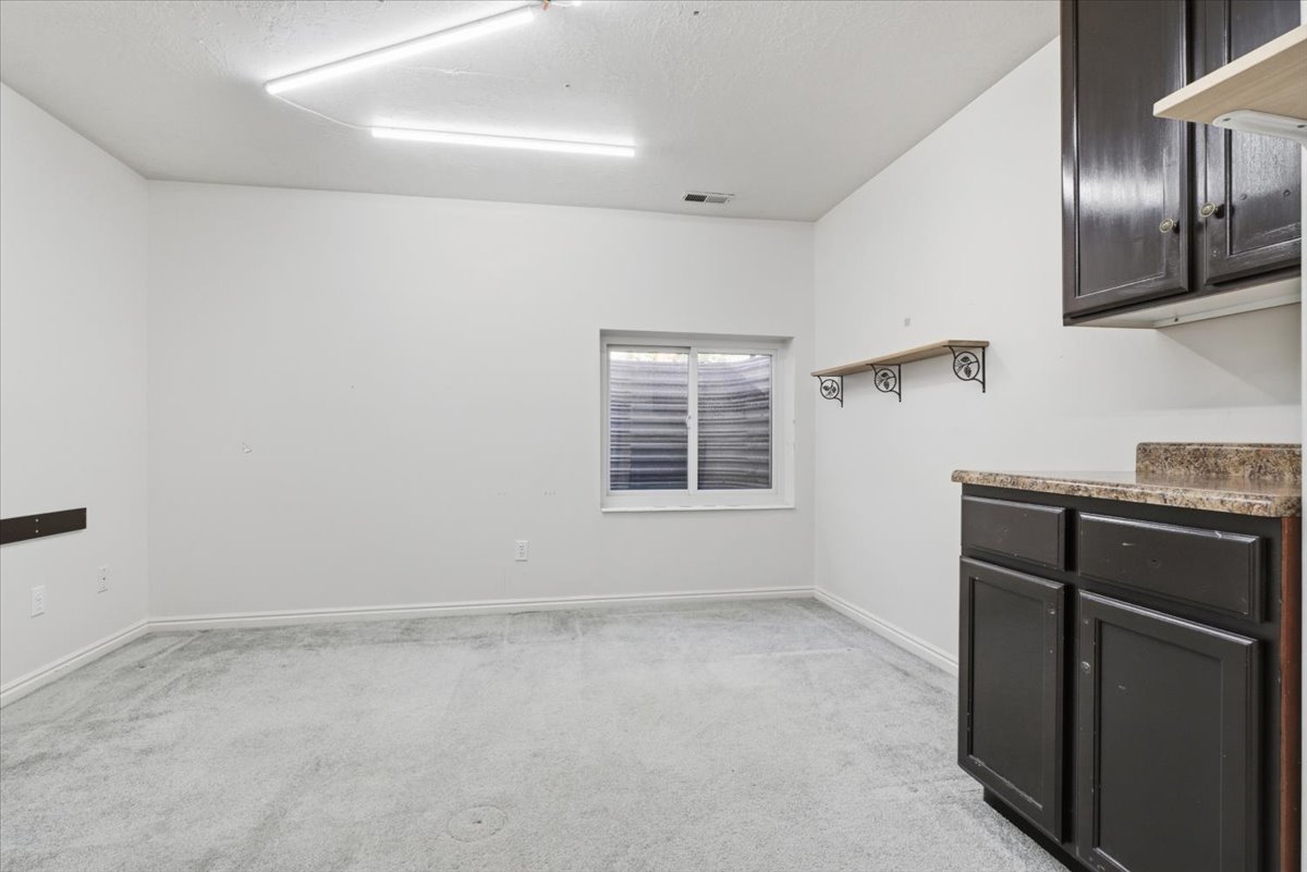 Spare room with light colored carpet and baseboards