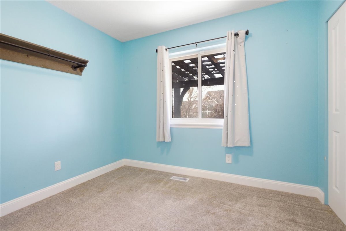 Carpeted spare room featuring baseboards