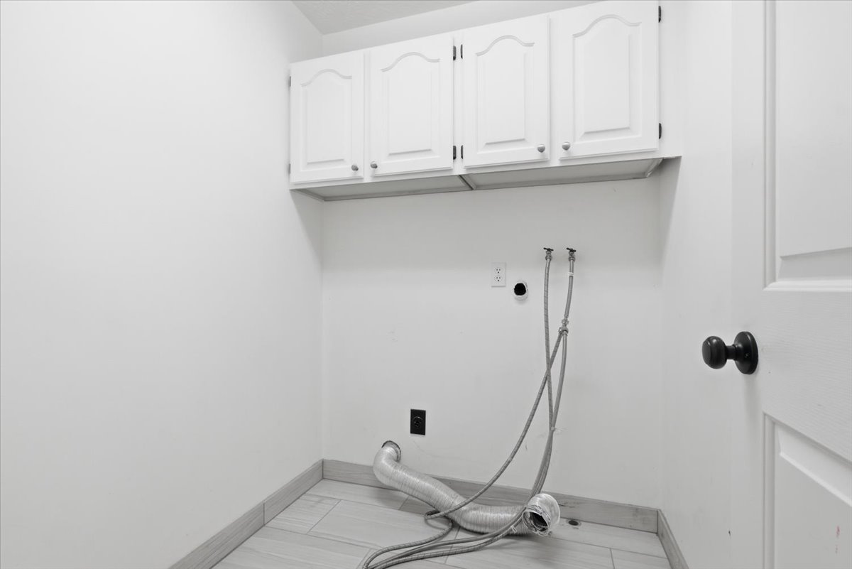 Laundry area with washer hookup, cabinet space, and electric dryer hookup