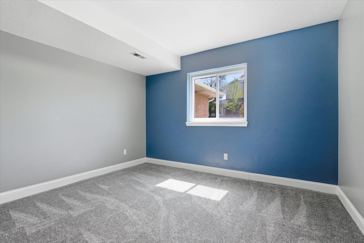 Spare room featuring light colored carpet and baseboards