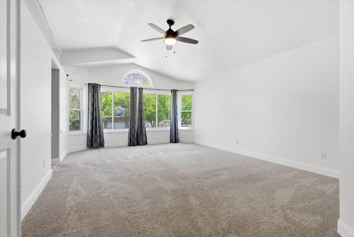 Unfurnished room featuring a ceiling fan and light colored carpet