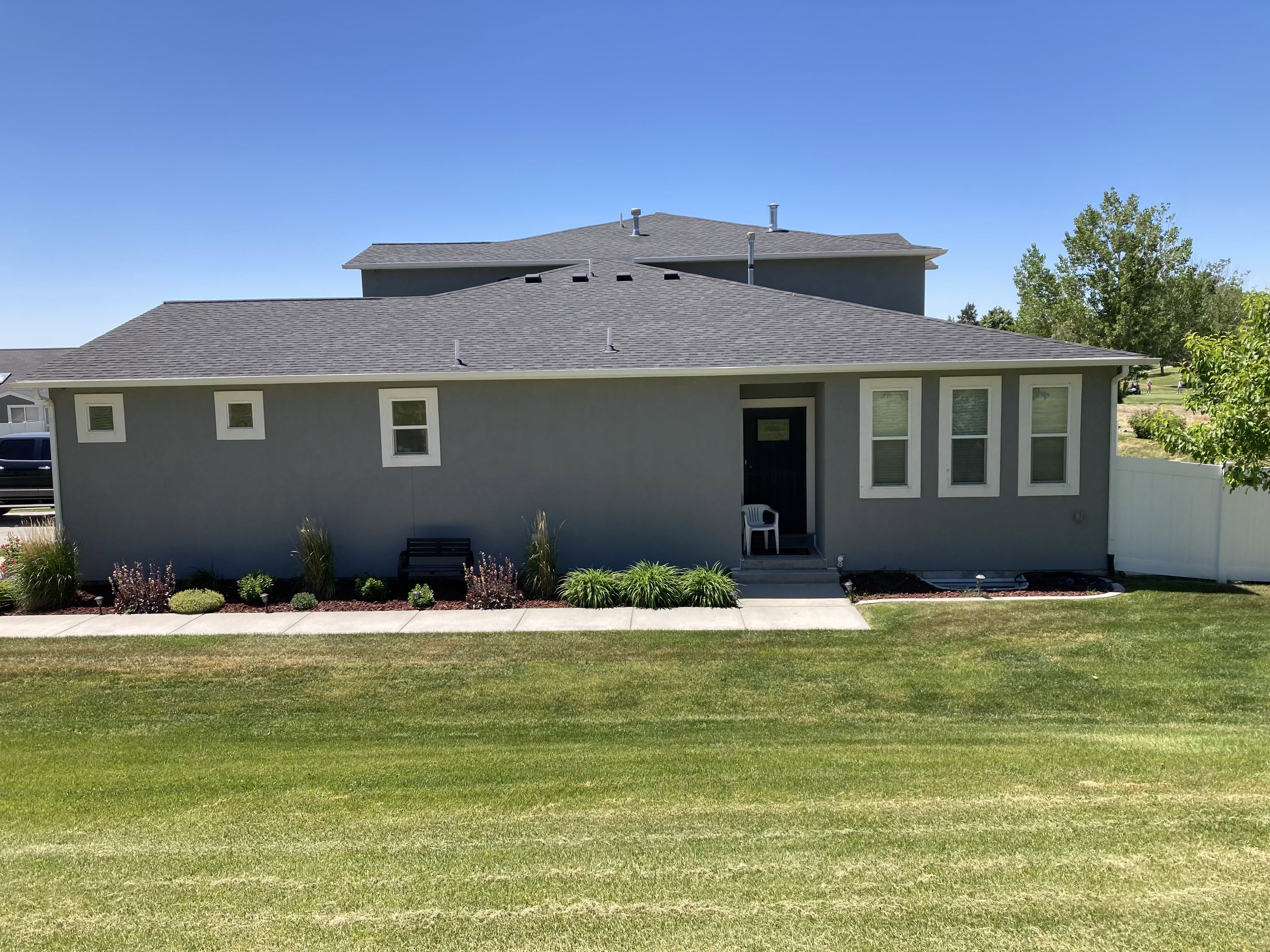 Rear view of property with roof with shingles and stucco siding