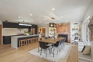 DINING AREA WITH EXPOSED ORIGINAL BRICK AND KITCHEN WITH BUTLER PANTRY
