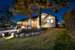 View of front facade with a yard and stucco siding