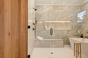 Bathroom with a freestanding bath, a marble finish shower, recessed lighting, and tile walls
