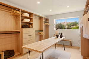 EXQUISITE PRIMARY CLOSET WITH CUSTOM BUILT-INS AND ROOM FOR MASSAGE OR FOLDING TABLE