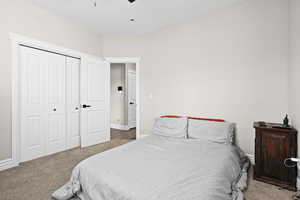 Carpeted bedroom featuring a closet and a ceiling fan