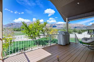 Deck featuring grilling area, a mountain view, and a lawn