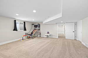 Recreation room with light carpet and recessed lighting
