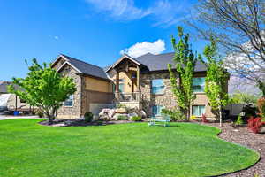 Craftsman inspired home with stone siding, a front lawn, and stucco siding
