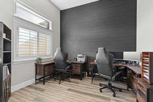 Office area featuring an accent wall and light wood-type flooring