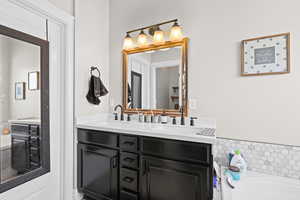 Full bathroom with double vanity and a bath