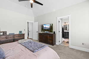 Bedroom with light carpet, a ceiling fan, lofted ceiling, and ensuite bathroom