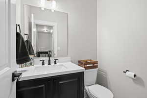 Half bathroom featuring vanity and toilet