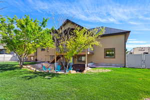 Rear view of house with a patio area, a wooden deck, a gate, and stucco siding
