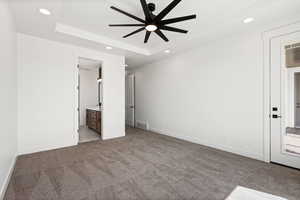 Unfurnished bedroom featuring light colored carpet, connected bathroom, recessed lighting, and ceiling fan
