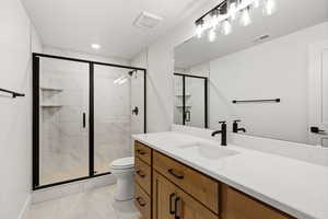 Bathroom with a marble finish shower and vanity
