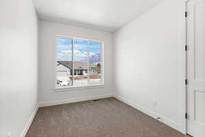 Unfurnished room featuring dark carpet and a mountain view