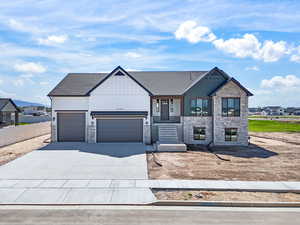 View of front of property with stone siding, a garage, driveway, and a porch