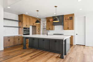 Kitchen with open shelves, dual tone cabinetry, a large island, light wood finished floors, and stainless steel double oven