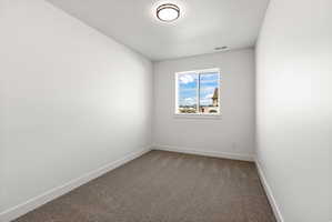 Unfurnished room with dark carpet and a textured ceiling