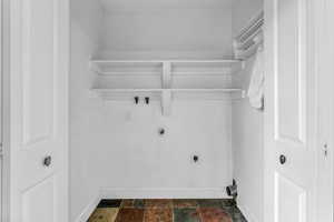 Laundry area with washer hookup, dark stone finish flooring, and electric dryer hookup