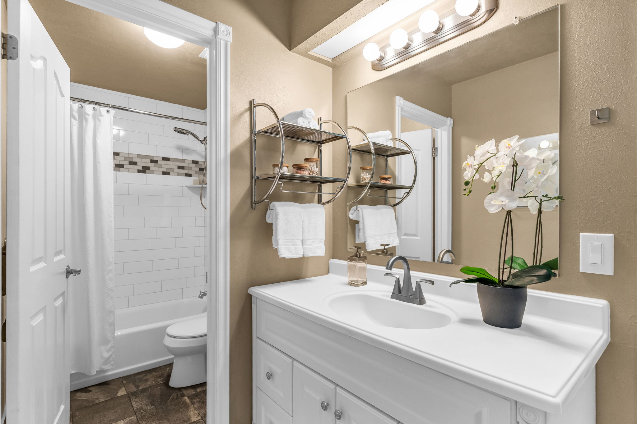 Full bathroom featuring vanity, shower / bath combination with curtain, and stone finish flooring