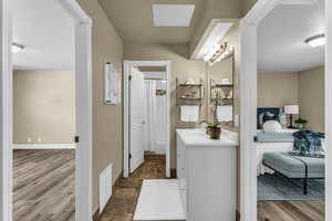 Ensuite bathroom with vanity, curtained shower, and dark stone finish flooring