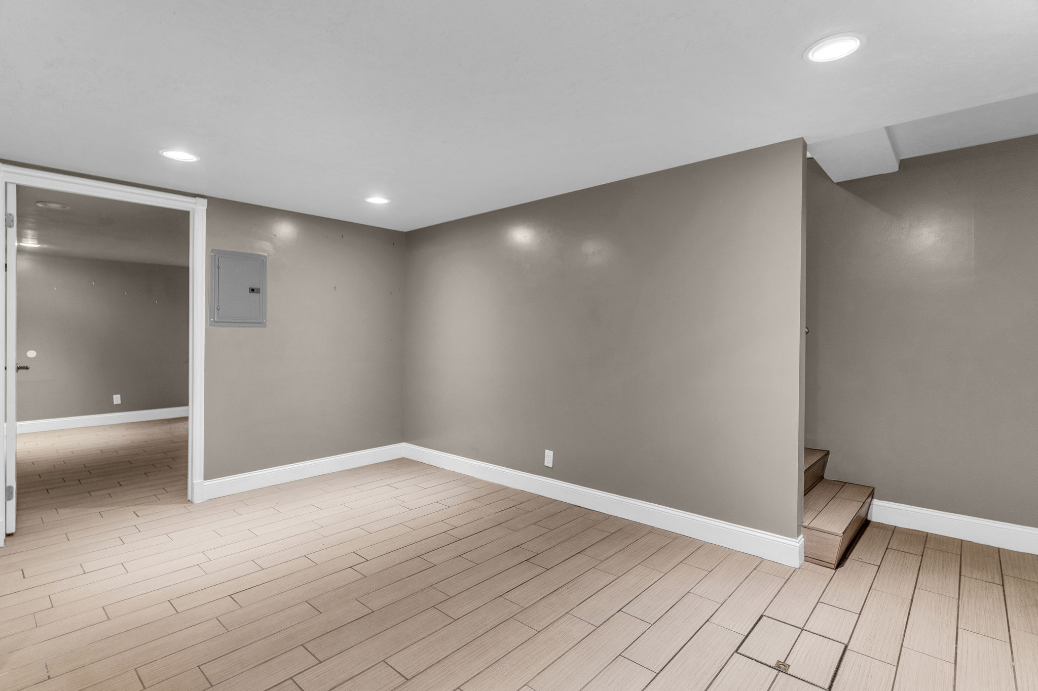 Finished basement featuring recessed lighting, wood tiled floors, and electric panel
